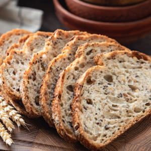 Sliced multigrain bread on wooden cutting board